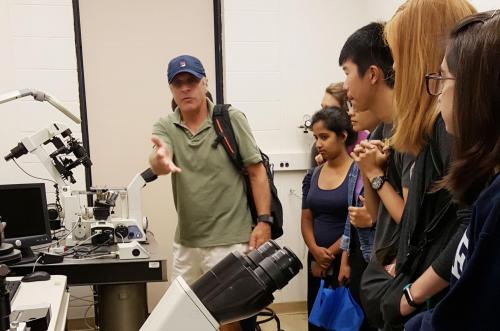 Prof. Paul Forscher giving a tour to students on various microscopy setups.